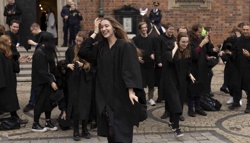Studenci ubrani w czarne togi zbierają czapki, które rzucali w górę po odśpiewaniu Gaudeamus igitur; Rynek, inauguracja roku akademickiego 2022/2023