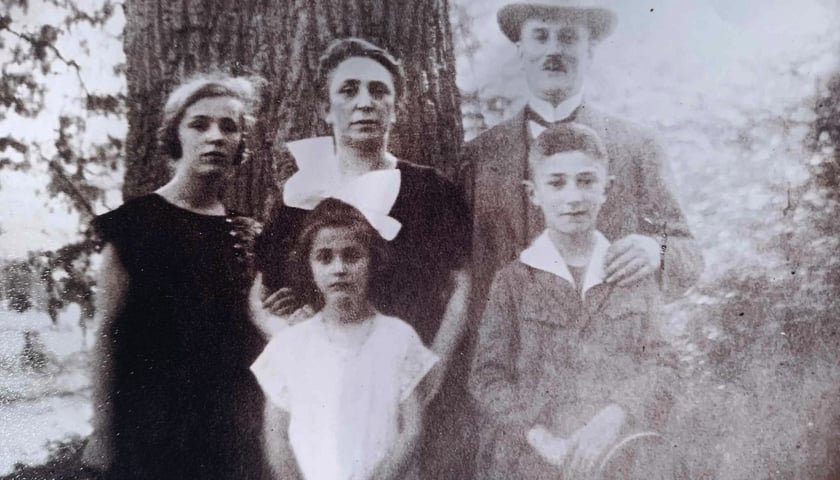 Na czarno-białym zdjęciu dwoje dorosłych: mężczyzna w kapeluszu i kobieta, oraz dzieci, dwie dziewczynki i chłopiec.