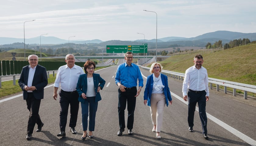Premier Morawiecki i inni uczestnicy konferencji prasowej idą drogą S3