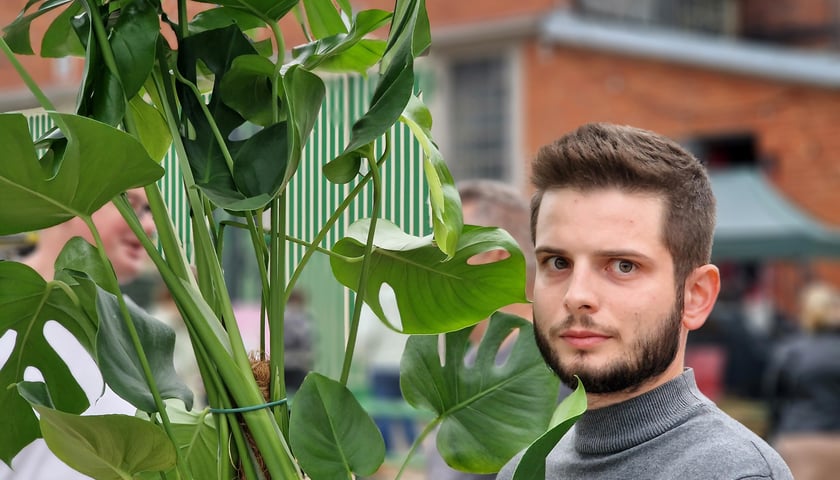 Festiwal roślin doniczkowych. Na zdjęciu Kacper Kuszaj, który kupił tam okazałą monsterę. W tle zabudowania dawnej zajezdni tramwajowej