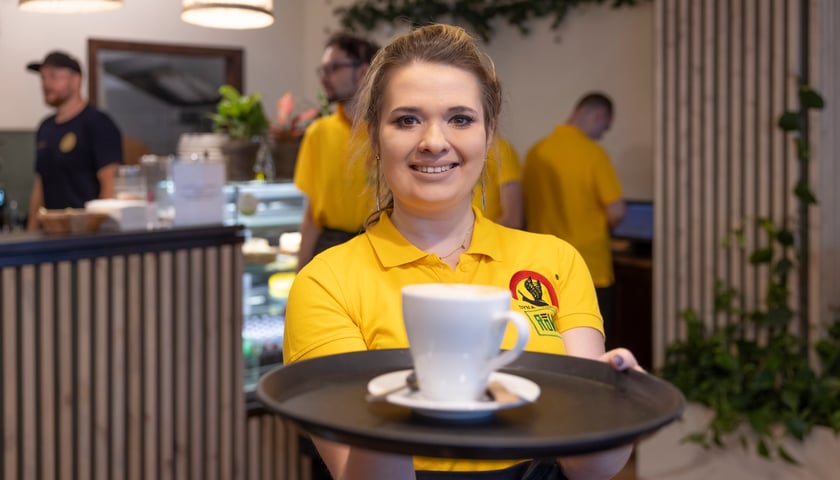 Cafe Równik po metamorfozie. Na zdjęciu uśmiechnięta kelnerka i baristka, w tle odmienione wnętrze.