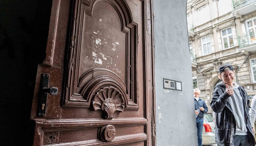 Filip Heliasz obok zabytkowych, drewnianych drzwi jednej z wrocławskich kamienic
