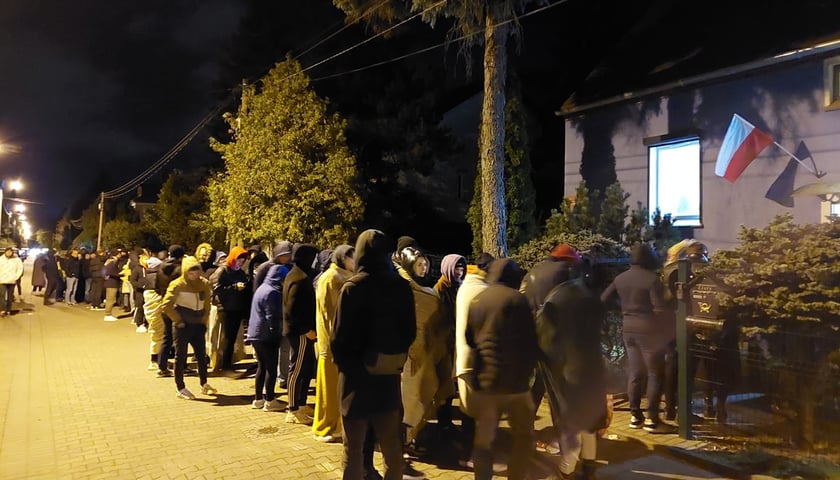 Na zdjęciu kolejka ciepło ubranych ludzi przed lokalem wyborczym