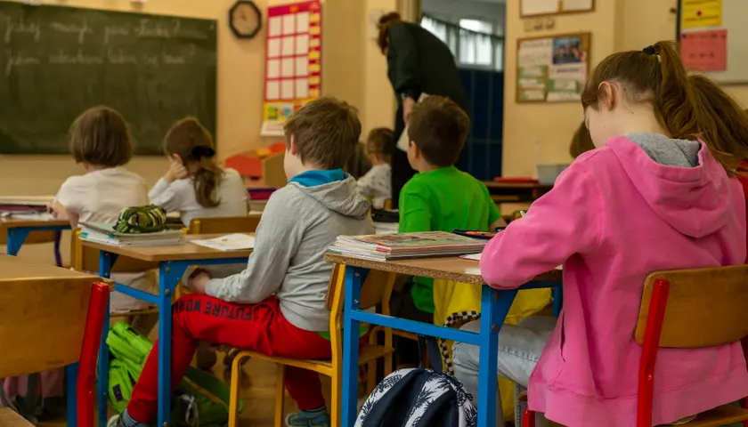 zdjęcia uczniowie w ławkach w sali lekcyjnej