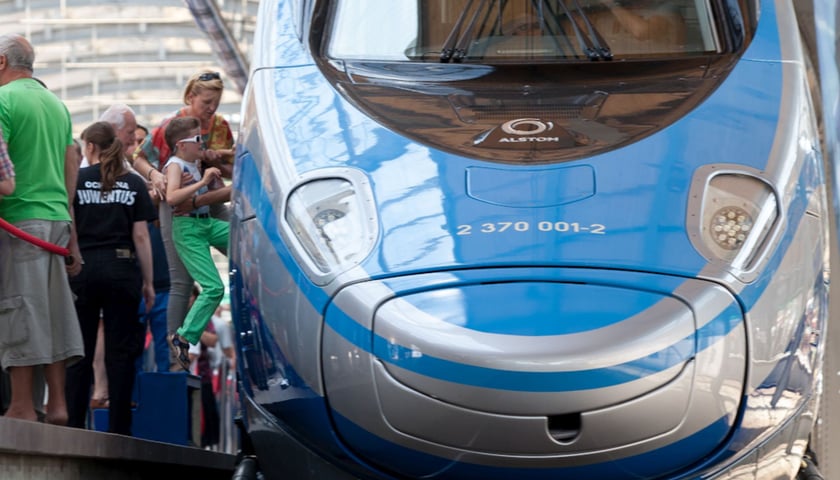Pociąg Pendolino w kolorze niebieskim na dworcu, z lewej widać wsiadających pasażerów