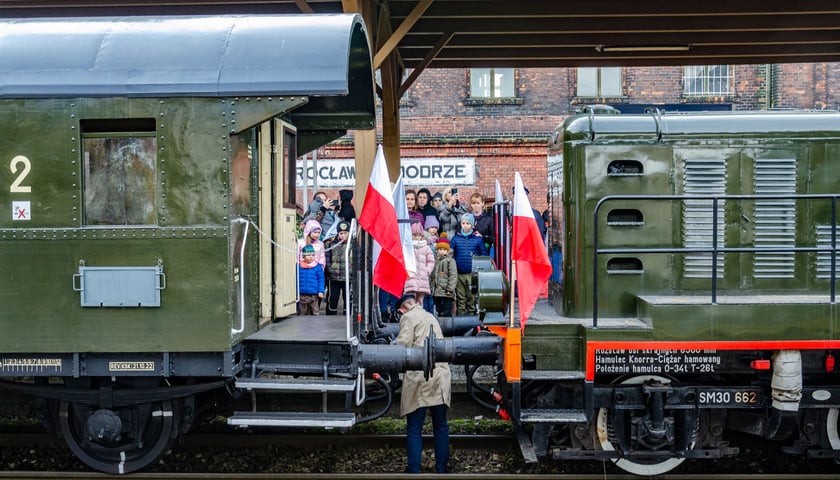 Pociąg retro z flagami i pasażerowie na stacji Wrocław Nadodrze