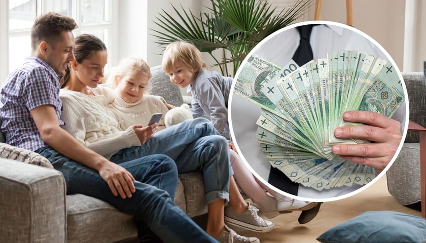 Mężczyzna, kobieta, dziewczynka i chłopiec patrzą telefon, w kółku plik banknotów w ręce, zdjęcie ilustracyjne 