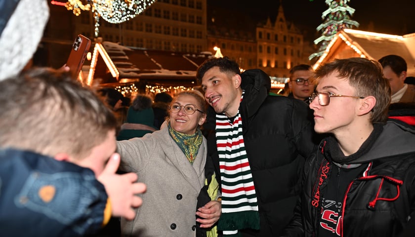 Uroczyste rozświetlenie choinki w Rynku. W środku Erik Exposito pozuje z mieszkańcami