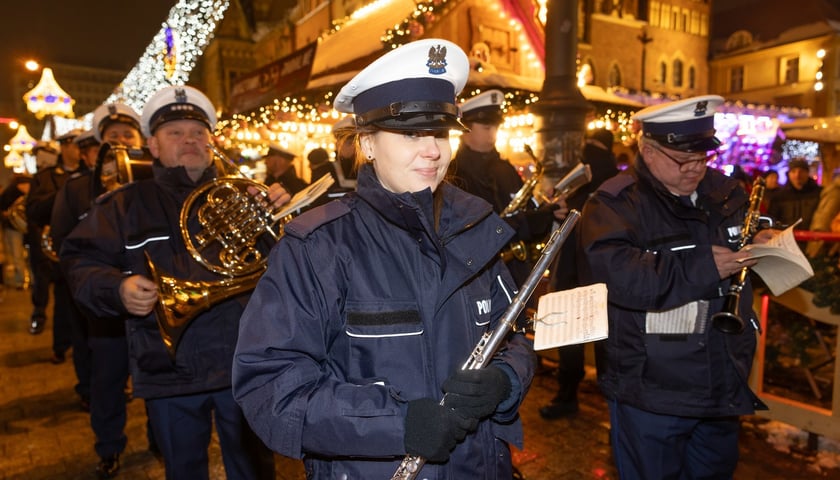 Mężczyźni i kobiety w mundurach policji i z instrumentami muzycznymi w rękach, specjalny występ Orkiestry Komendy Wojewódzkiej Policji we Wrocławiu na Jarmarku Bożonarodzeniowym