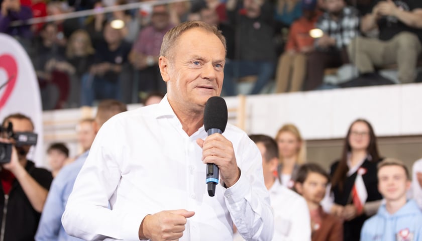 Donald Tusk w białej koszuli przemawia do mikrofonu, wizyta na wrocławskim Jagodnie po wyborach parlamentarnych