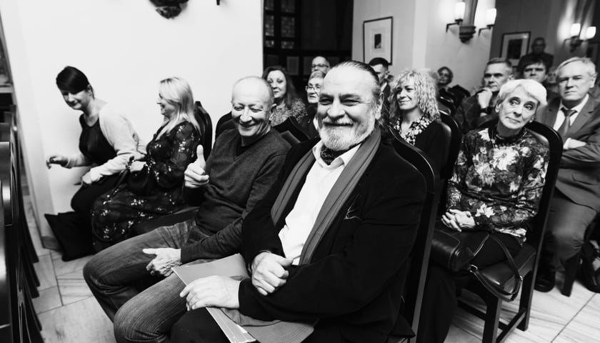 Nauczyciele siedzą na krzesłach w Ratuszu podczas uroczystości wręczenia wyróżnień. Wśród nich Ludwik Ralski