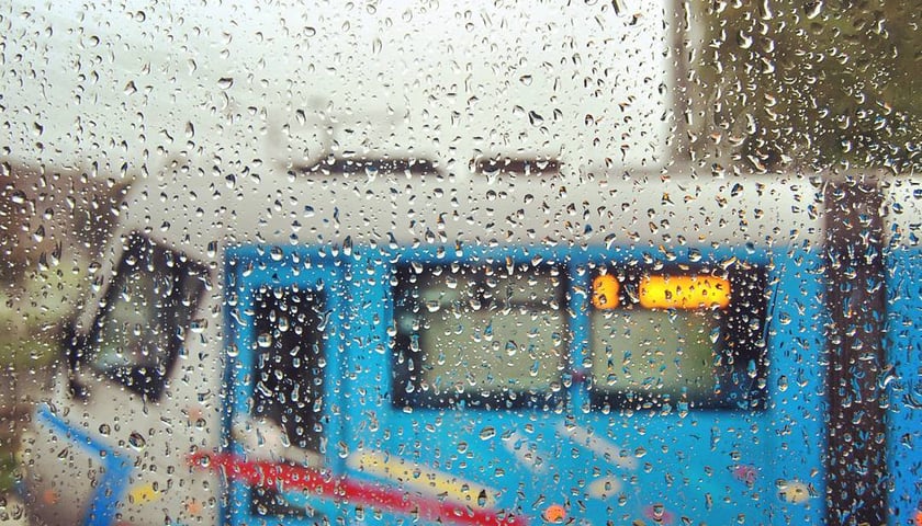 Wagon tramwaju sfotografowany przez mokrą szybę.