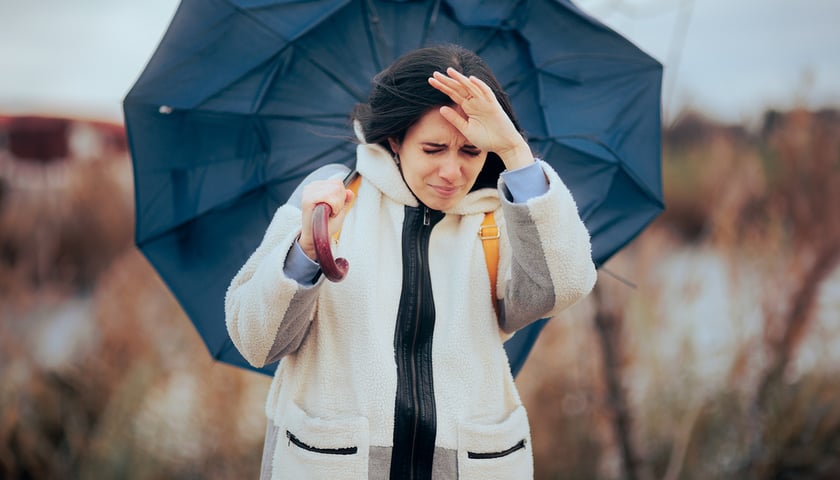 Kobieta z parasolem stawia czoło silnemu wiatrowi (zdjęcie ilustracyjne)