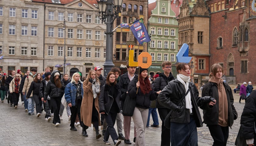 Korowód par tańczących Poloneza dla Fredry wokół Ryku (2023 rok). Uczniowie trzymają napis LO 4. 