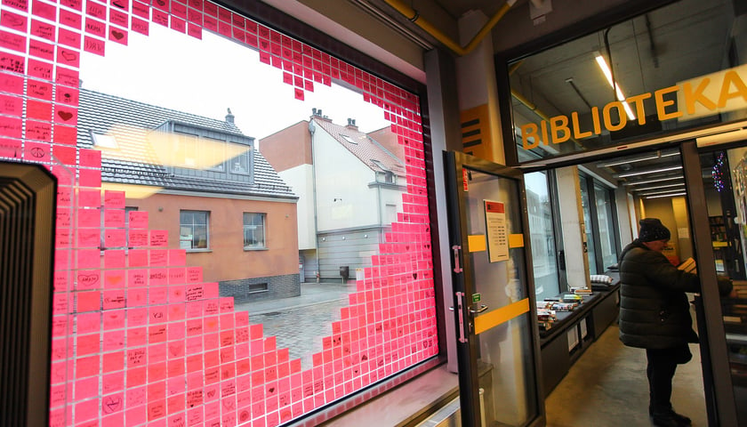 Widok serca z karteczek post-in od wewnątrz. W głębi wejście do biblioteki 