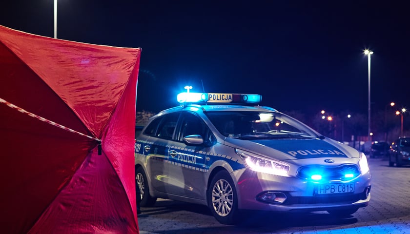 Czerwony namiot i wóz policyjny na sygnale (zdjęcie ilustracyjne) 