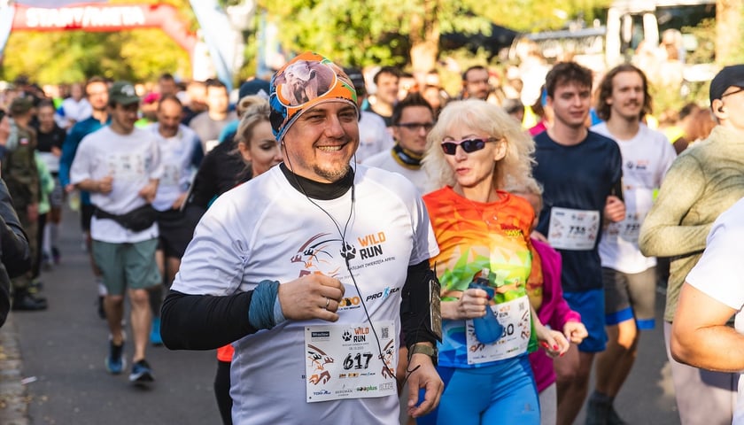 Na zdjęciu osoby uczestniczące w biegu charytatywnym Wild Run w roku 2023 - w strojach sportowych, na trasie