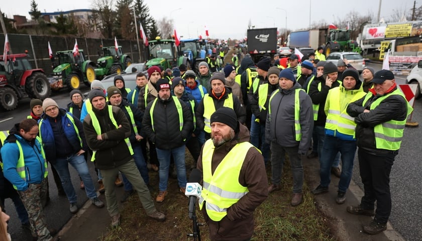 Rolnicy blokujący aleję Jana III Sobieskiego we Wrocławiu, ubrani w odblaskowe kamizelki. W środku Dominik Nikody (poranek 12 lutego 2024)  