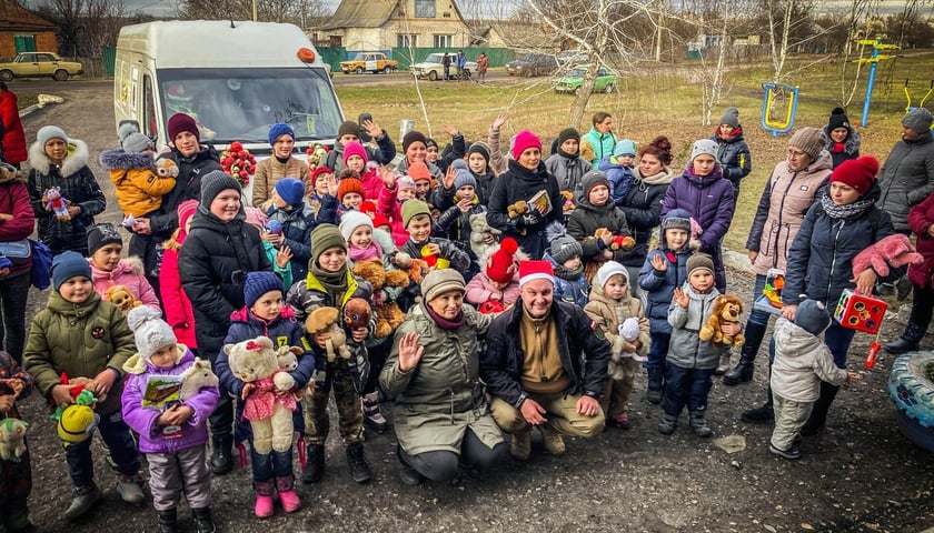 Piotr Kaszuwara i dzieci, które dostały prezenty przywiezione zniszczonym teraz reniferobusem