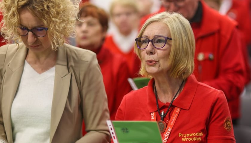 Uroczystości z okazji Międzynarodowego Dnia Przewodnika. Dwie kobiety, po lewej w beżowym żakiecie, po prawej w czerwonej koszulce z napisem "Przewodnik Wrocław"