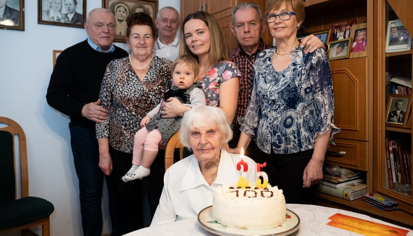 Na zdjęciu 100-letnia Józefa Grzesiak z tortem ze świeczkami 25 i napisem 100 w otoczeniu najbliższej rodziny, z najmłodszą aktualnie prawnuczką - Olą