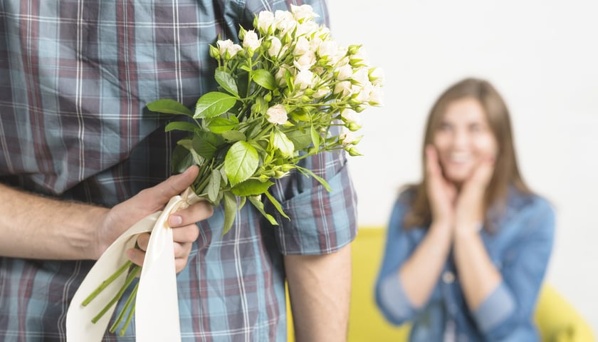 Mężczyzna wręczający kwiaty kobiecie / zdjęcie ilustracyjne