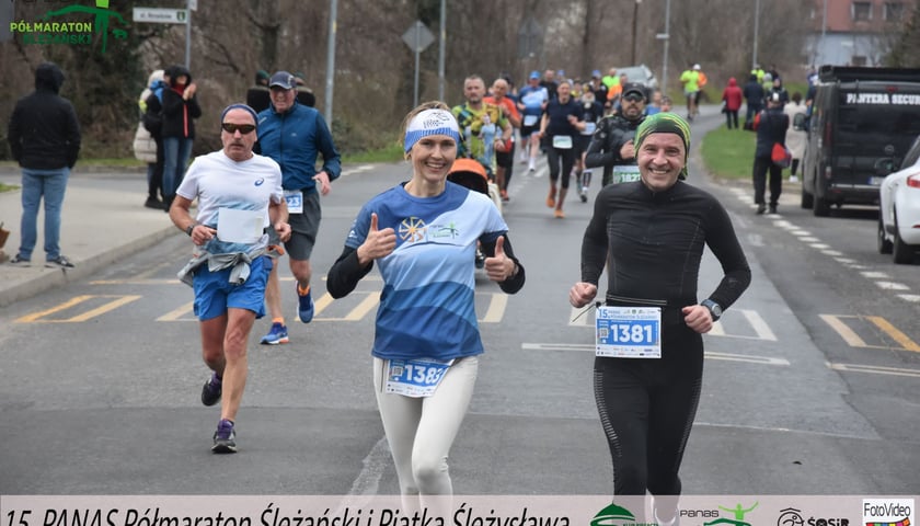 Zawodnicy na mecie Półmaratonu Ślężańskiego. Na pierwszym planie kobieta i po bokach dwóch mężczyzn