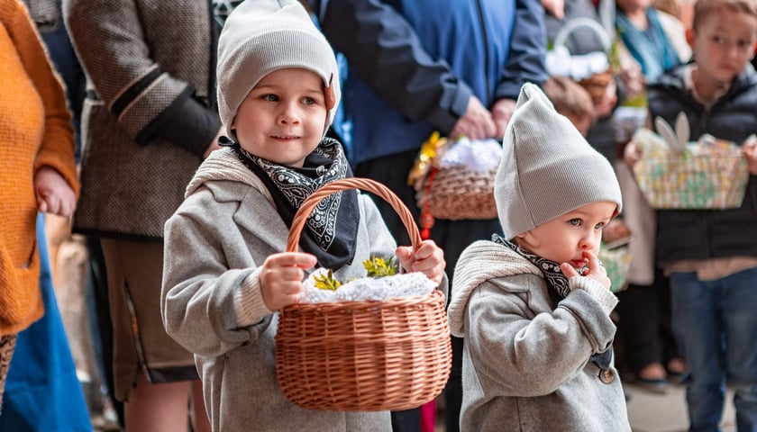 Święcenie pokarmów w Wielką Sobotę we Wrocławiu - na zdjęciu dzieci trzymają koszyczek wielkanocny