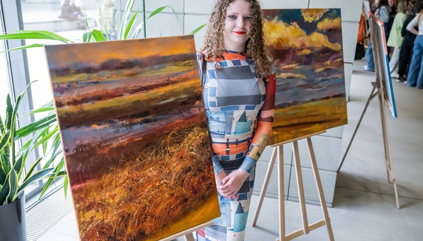 <p>Martyna Kaszyca przed swoimi obrazami</p>