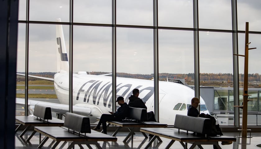 Pasażerowie oczekujący na lotnisku Helsinki-Vantaa i samolot linii Finnair (zdjęcie ilustracyjne)