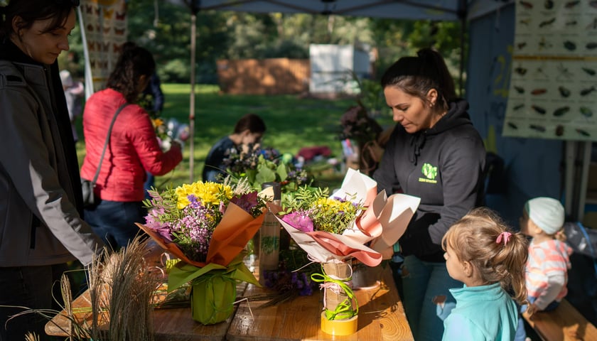 Kompozycje kwiatowe układane podczas rodzinnego pikniku - jesienna edycja WROśnij we WRO 2023 w parku Zachodnim
