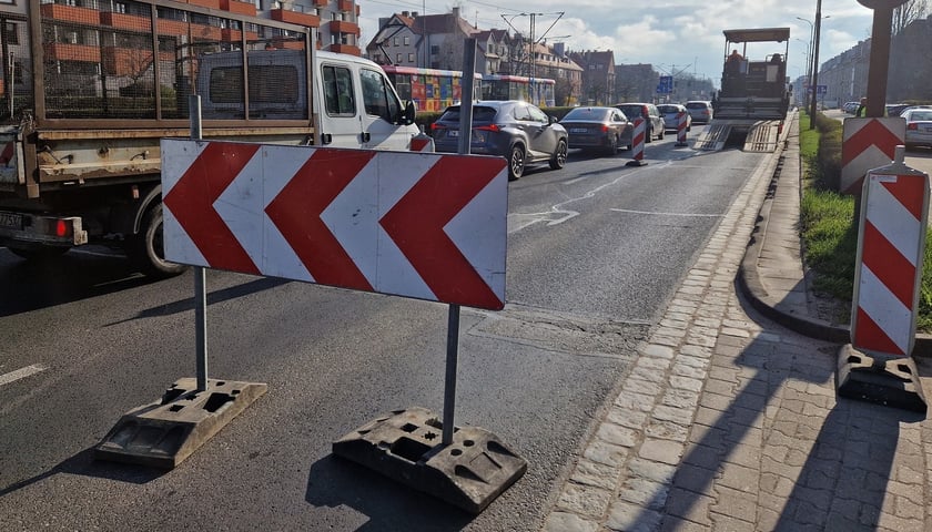 Barierki na jezdni, w tle samochody, zdjęcie ilustracyjne