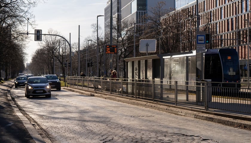 Brukowa nawierzchnia Powstańców Śląskich, samochody jadące ulicą