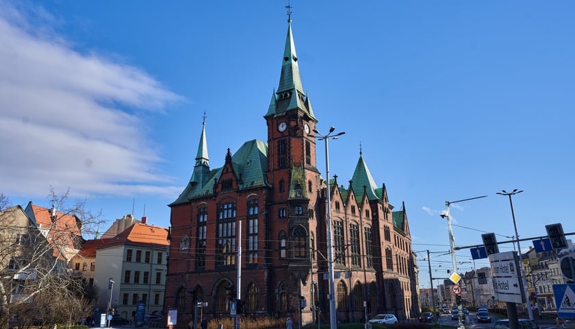 Budynek dawnej Biblioteki Uniwersyteckiej przy ul. Szajnochy. Na zdjęciu widać ogromny budynek z czerwonej cegły, z wieżą zegarową, stromymi dachami 