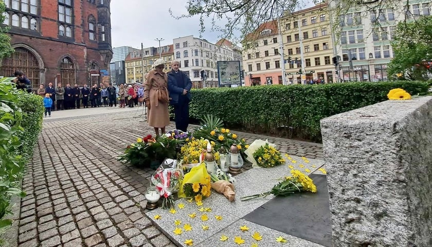 Uroczystości w 81. rocznicę wybuchu powstania w getcie warszawskim. na zdjęciu przed pomnikiem leżą żonkile i stoją dwie osoby, mężczyzna i kobieta