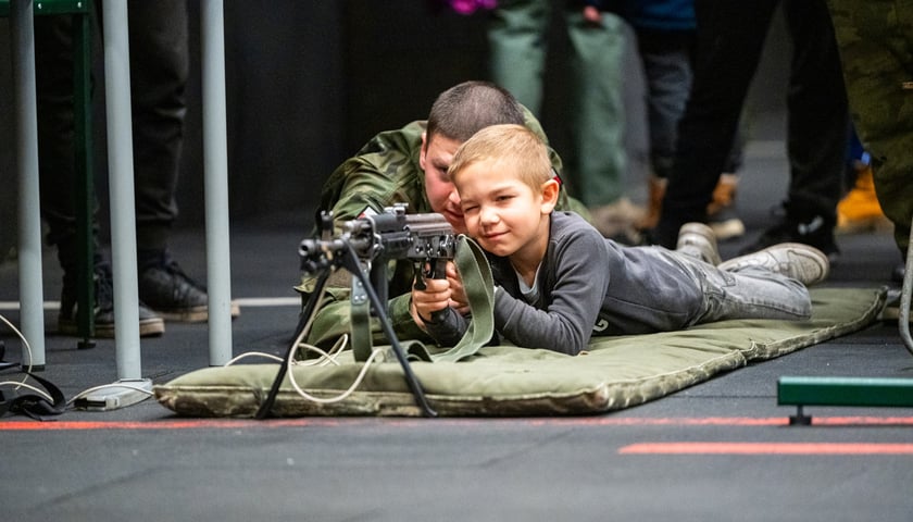 Chłopiec uczący się strzelania z karabinu