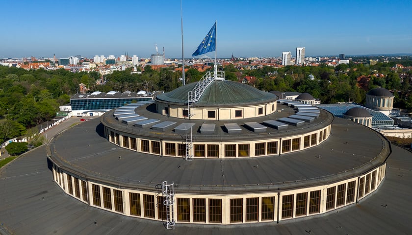 Na zdjęciu kobieta na tle flagi Unii Europejskiej. Sprawdź najważniejsze informacje dotyczące wyborów do Parlamentu Europejskiego 2024
