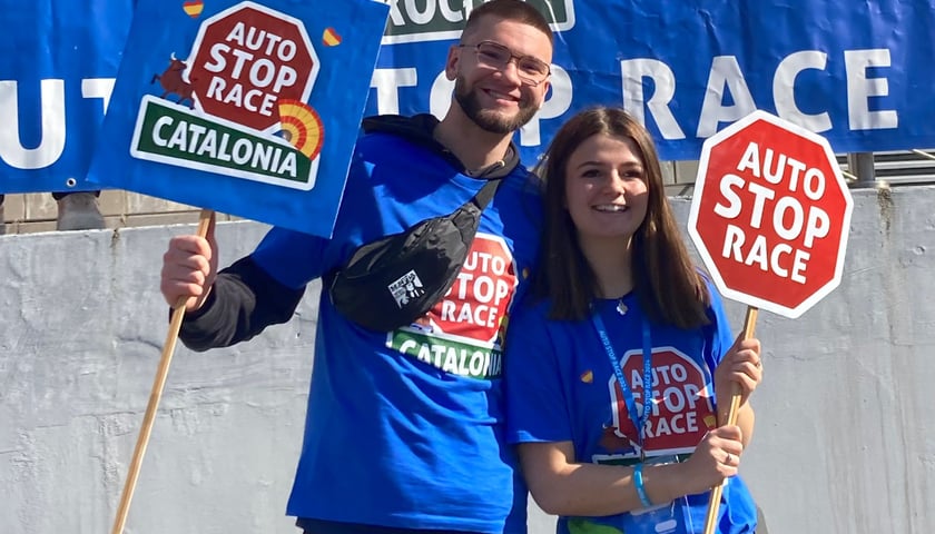 Chłopak i dziewczyna z transparentami z napisem Autostop Race