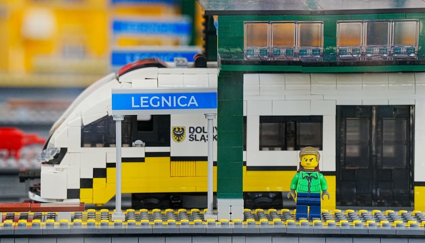 Fragment makiety kolejowej z Lego: widać kawałek stacji Legnica, pociąg i pasażera