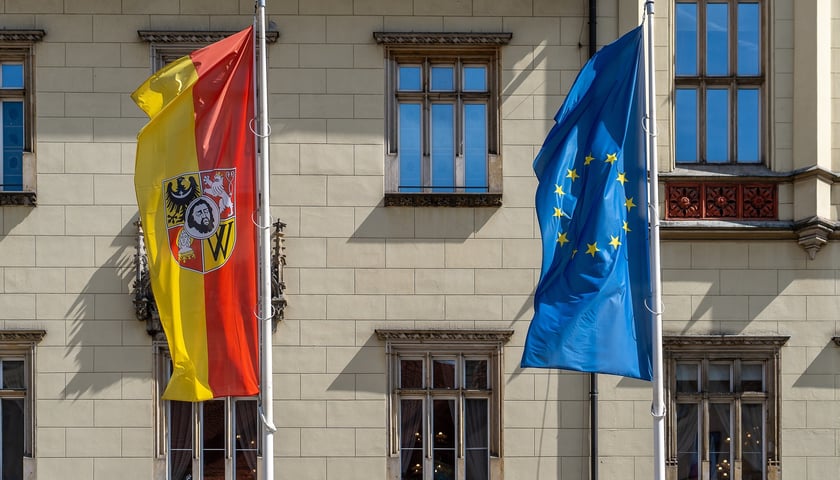 Flaga Wrocławia i Unii Europejskiej zawieszone na masztach na wrocławskim Rynku