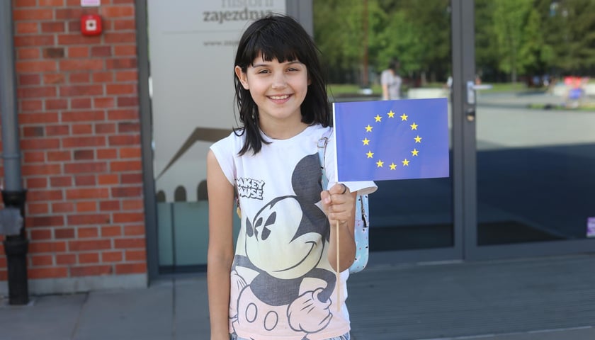 20 lat w Unii Europejskiej – radosne obchody podczas Majówki w Centrum Historii Zajezdnia. Na zdjęciu uśmiechnięta dziewczynka trzyma flagę Unii Europejskiej