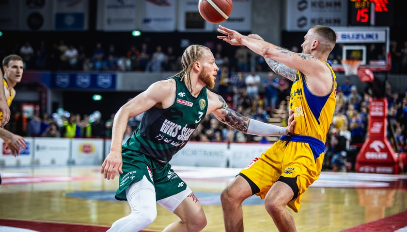 Hassani Gravett (13 punktów, 7 zbiórek i 6 asyst) pilnuje podającego Aigarsa Skele (25 punktów, 10 asyst) w meczu 5. 