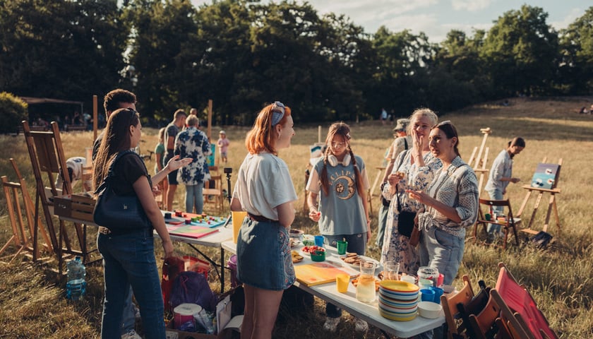 Grupa mieszkańców w parku Tołpy, podczas wspólnego malowania w plenerze. Zdjęcie archiwalne, wykonane podczas jednego z minionych wydarzeń organizowanych w ramach Mikrograntów.
