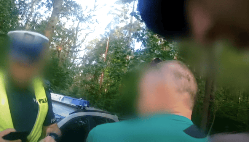 Na stopklatce z filmu widać tył głowy zatrzymanego, policjanta, a w tle radiowóz. Twarze i inne szczegóły są rozmazane