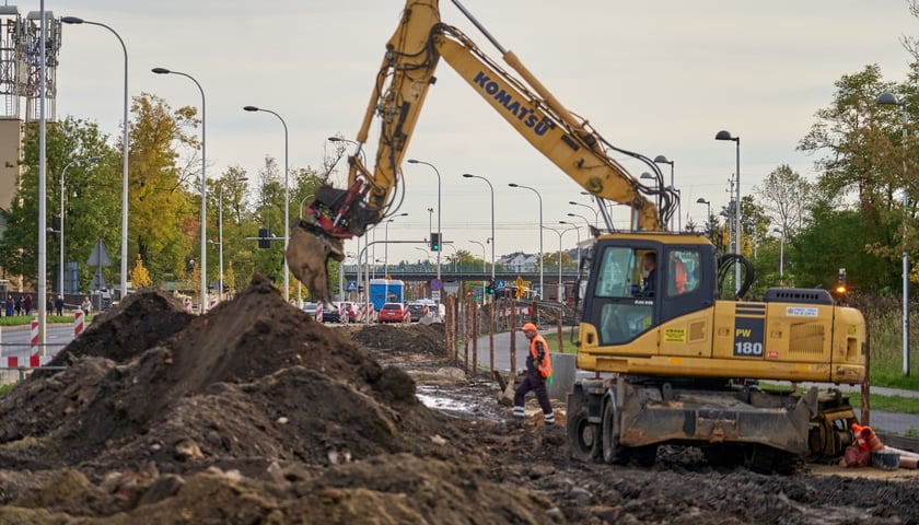 Archiwalne zdjęcie z budowy buspasa na Jagodno przedstawia rozkopany teren i koparkę. 