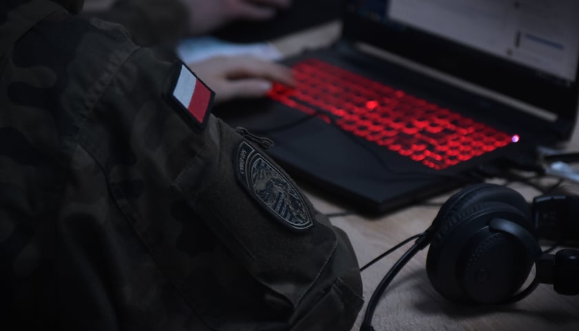 Żołnierz WOC przed laptopem.
