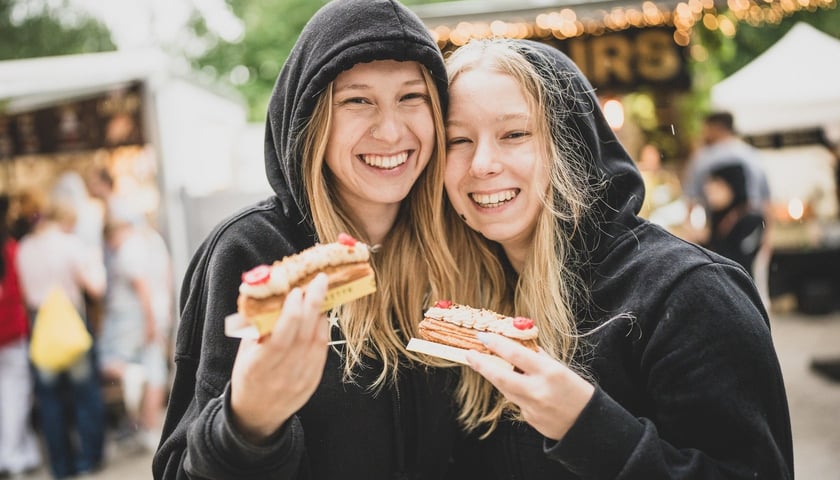 Gastro Miasto na bulwarze Dunikowskiego. Dwie młode, uśmiechnięte kobiety z kanapkami