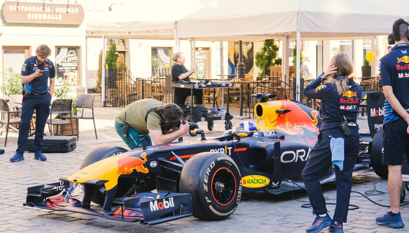 Bolid F1 RB7 na Rynku, wokół niego ekipa Red Bulla