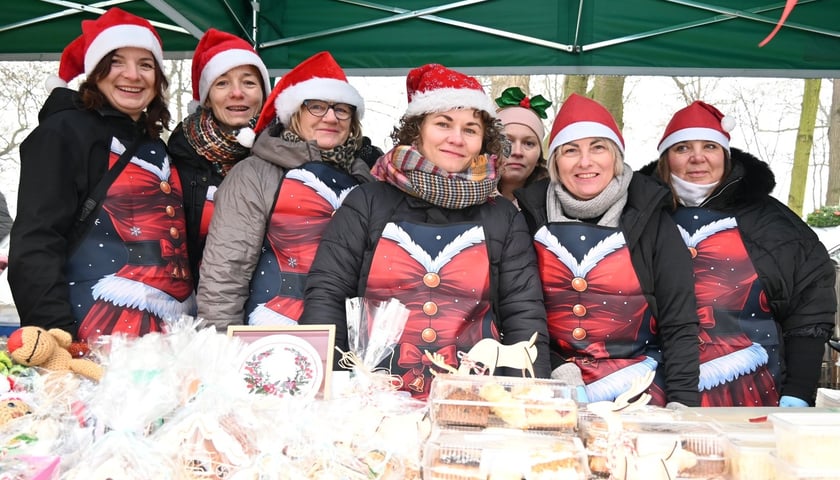 7 kobiet w świątecznych ubraniach. Panie z KGW Jarzębinki z Golędzinowa. Targ Rolny na ul. Zwycięskiej we Wrocławiu, 13 grudnia 2025 r. 