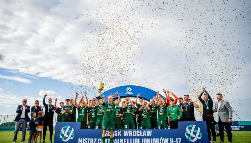 Piłkarze Śląska Wrocław U17 mistrzami Polski. Na zdjęciu cieszą się i wznoszą trofeum